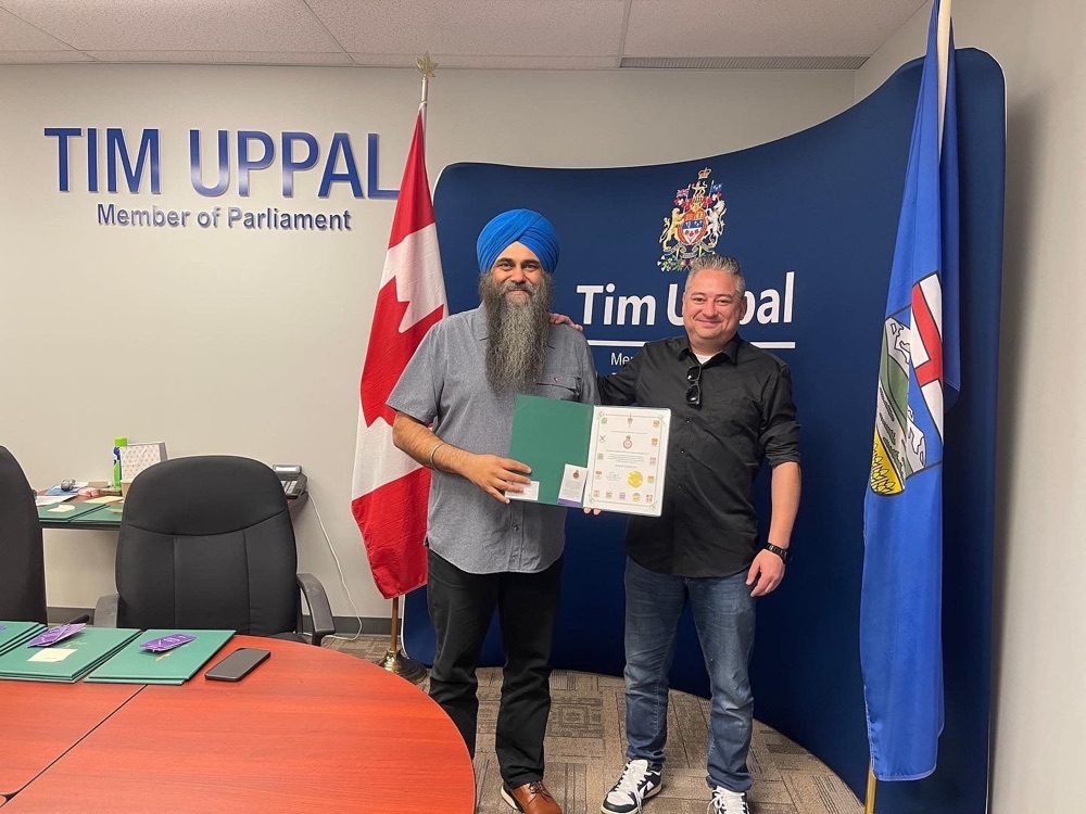 Ricardo Casanova receiving the federal Platinum Jubilee Pin and certificate from a Member of Parliament